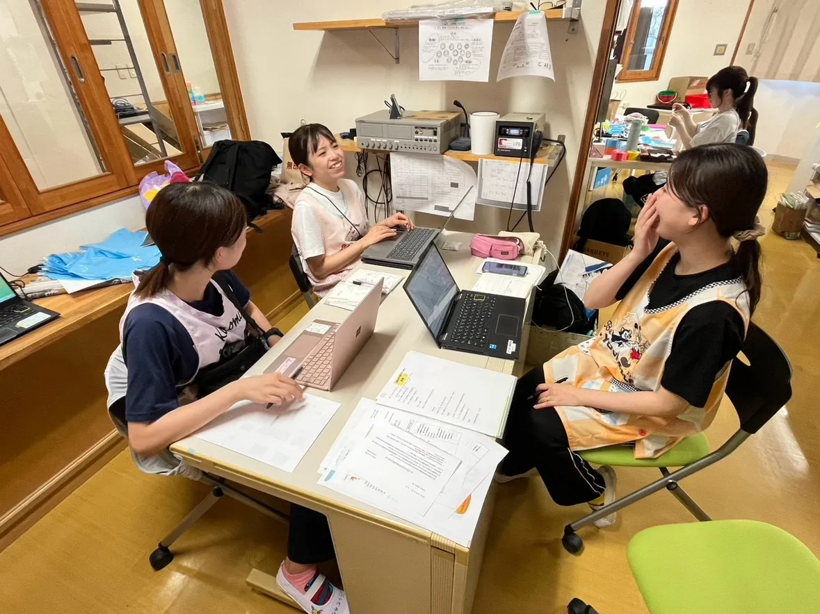 机を囲んで話し合う先生たち